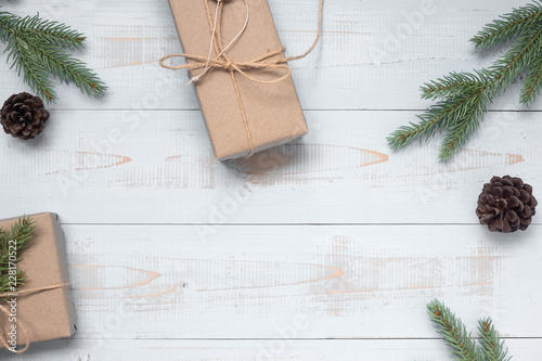 Christmas decoration, gift box and pine tree branches on wooden background, preparation for holiday concept, Happy New Year and Xmas Holidays. Top view and Copy Space for text