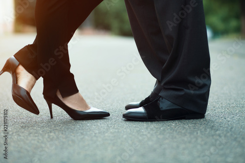 Man and woman in luxury shoes standing in the street. Business meeting outside.
