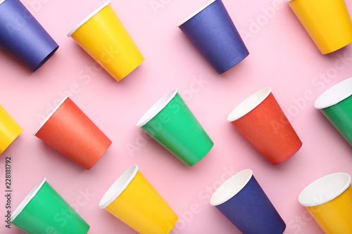 Colorful paper cups on pink background