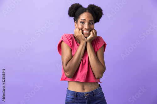 Photo of cheerful african american woman smiling and touching face, isolated over violet background