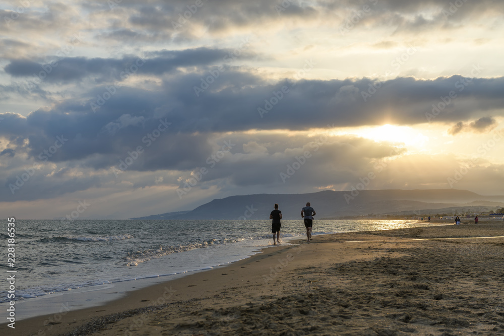couple running on the beach at sunrise