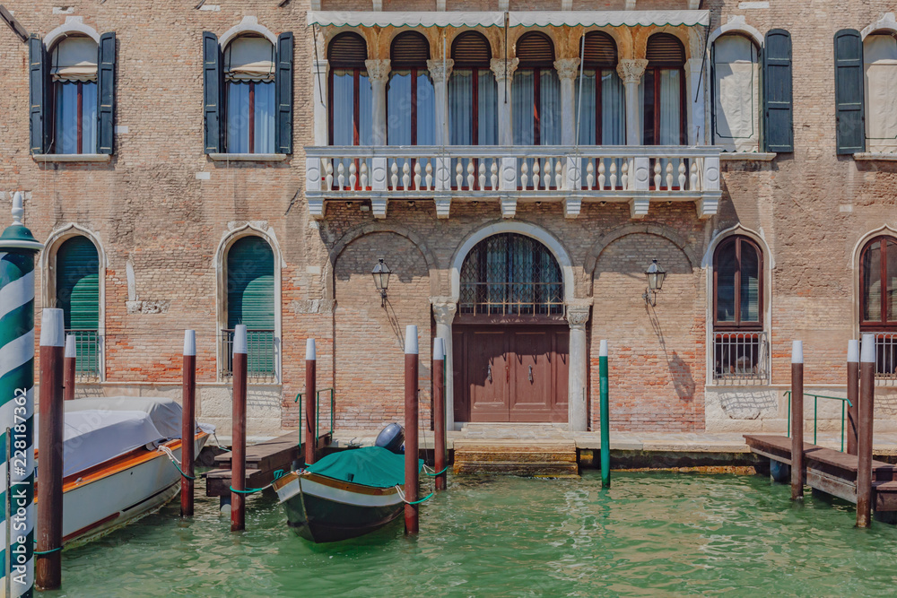 Venetian house and boats by canal in Venice, Italy