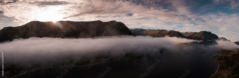 Aerial Drone Panorama of Mountain Silhouette above Clouds in Forest with Fog in Norway