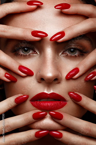Beautiful girl with a classic make up and multi-colored nails. Manicure design. Beauty face. Photo taken in the studio