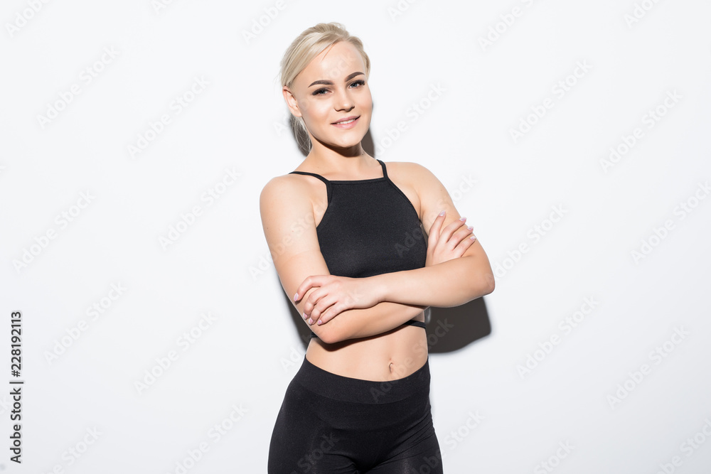 Portrait of a beautiful fitness woman with crossed arms on white background