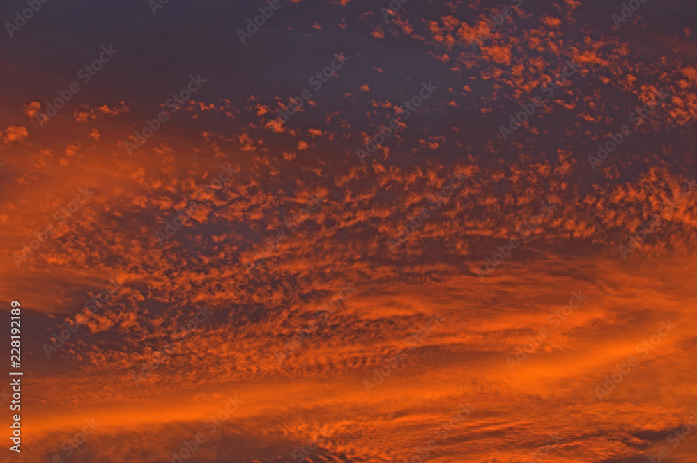 Obraz premium Chmury zabarwione na czerwono światłem zachodzącego słońca.