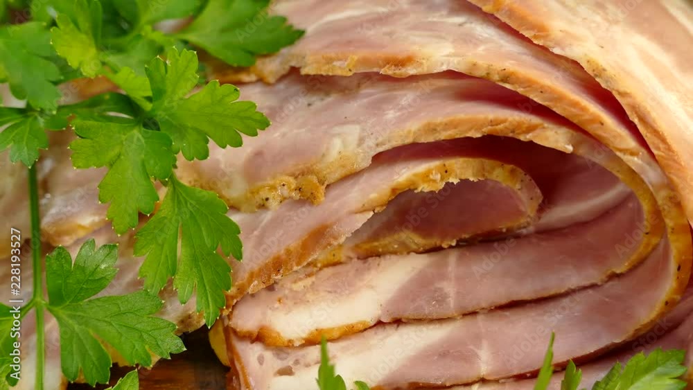 Bacon sliced on a cutting board with greens. Meat dinner with parsley. Bacon sliced on a cutting board with greens. Meat dinner with parsley.