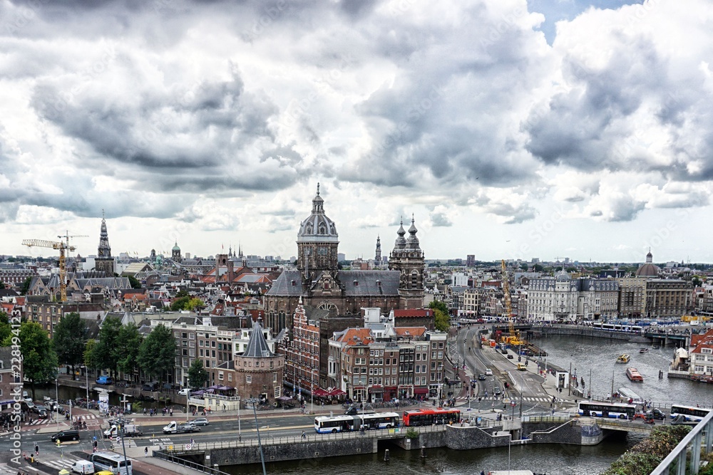 Stadtansicht vom Hafen Amsterdams mit dramatisch hängenden Wolken am Himmel