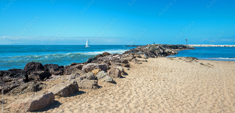 Fototapeta premium Sailboat going into Ventura Harbor in Ventura California United States