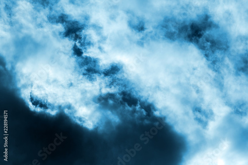 Background of transparent gray dramatic clouds in a blue sky.