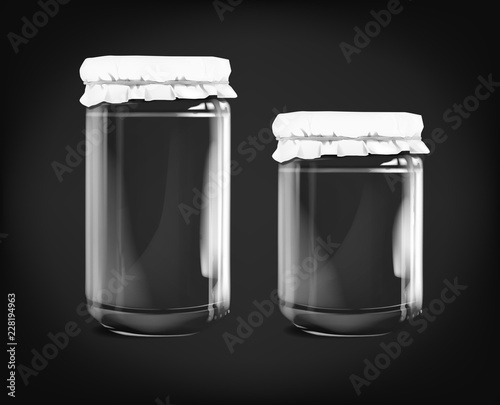Empty glass jar isolated on dark background.