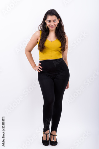 Full body shot of young happy Indian woman smiling with hand on 