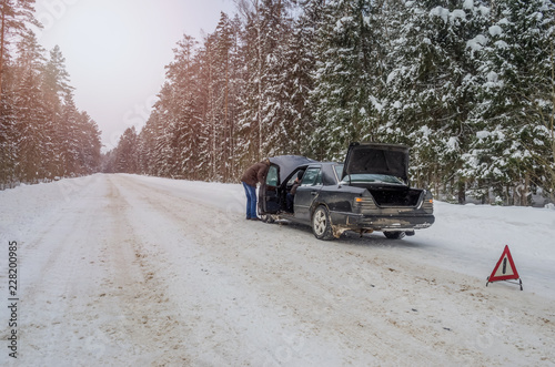 the men broke down the car on the road in winter