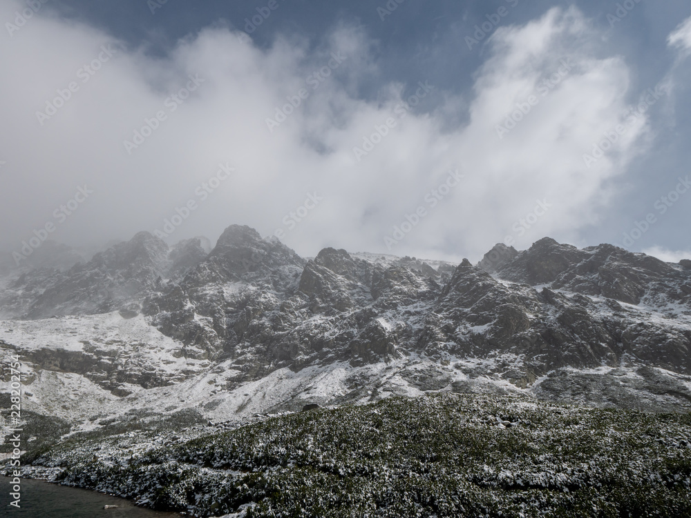 First snow in High Tatras. Beautiful winter mountains. Panorama of High Tatras. Big mountains and lake.