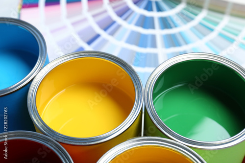 Obraz na plátně Paint cans and color palette samples on table, closeup