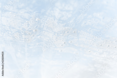 An abstract blue and white textured background with drops of moisture.