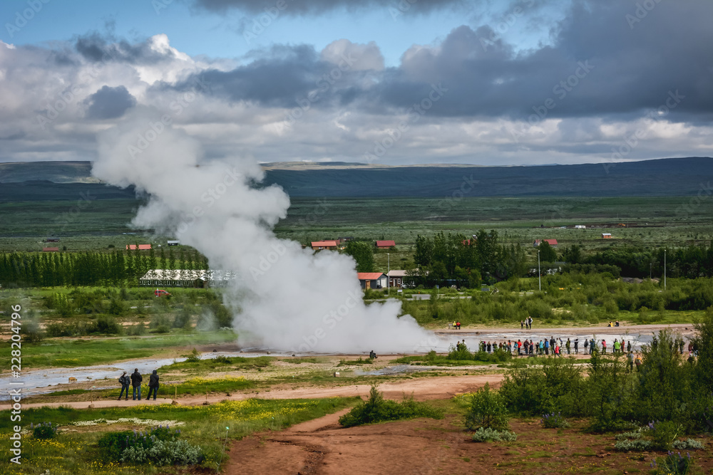 Fototapeta premium Eruption of Strokkur geyser in Iceland in summer with many tourists in the background