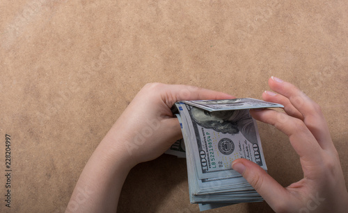 Hand holding American dollar  isolated on wooden background photo