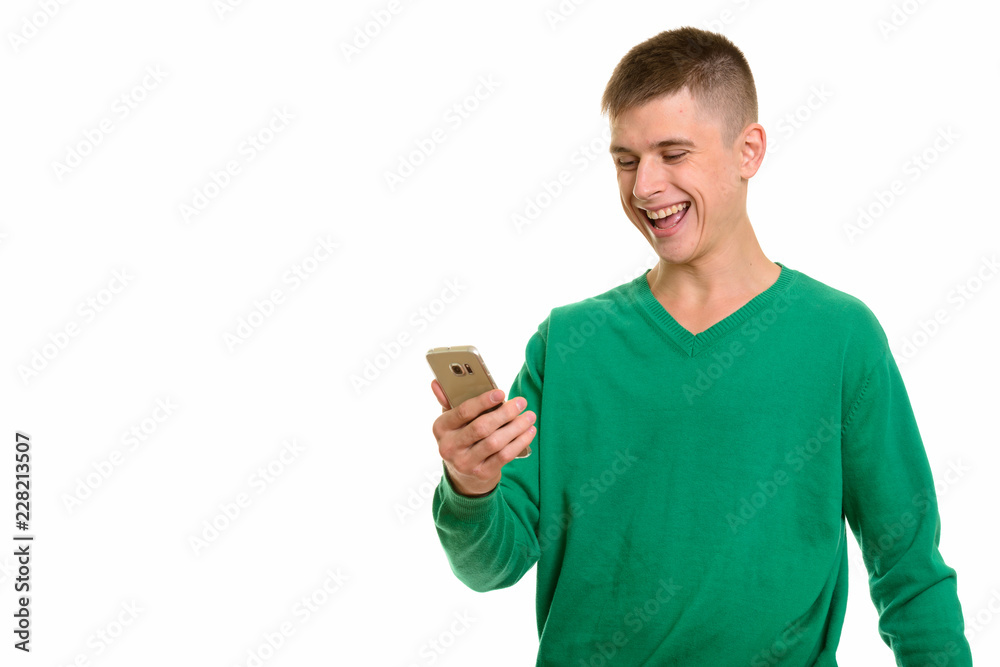 Young happy Caucasian man smiling and holding mobile phone Young happy Caucasian man smiling and holding mobile phone