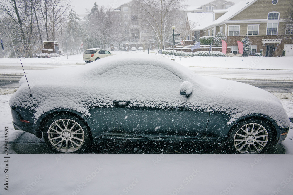 Cabriolet covered by snow during blizzard. Winter snow storm.