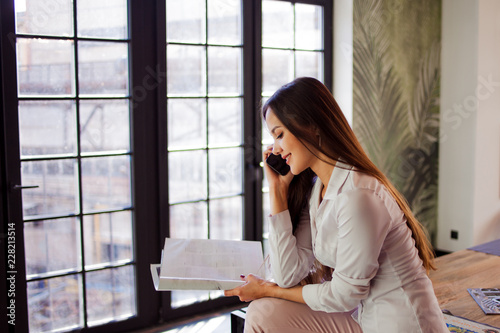 Happy young woman in comfortable loft style office.