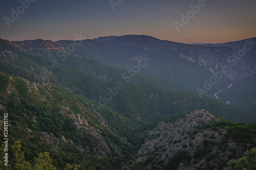Panoramic Mountain Landscape view during a beautiful sunset, with layered blue mountains and river, Sardinia, Orosei region. © janaland