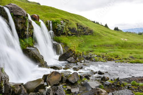 Thorsteinslundur waterfall  in motion blur on overcast summer day in Iceland.