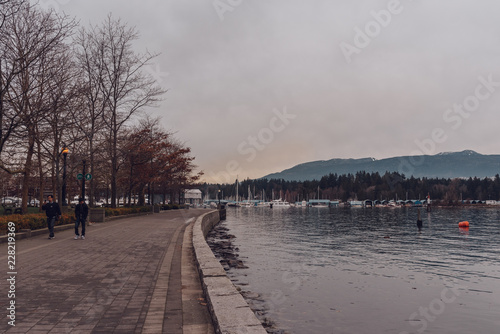 Vancouver  British Columbia Canada - December 24 2017  Coal harbour bay - waterfront in downtown park with some people walking.