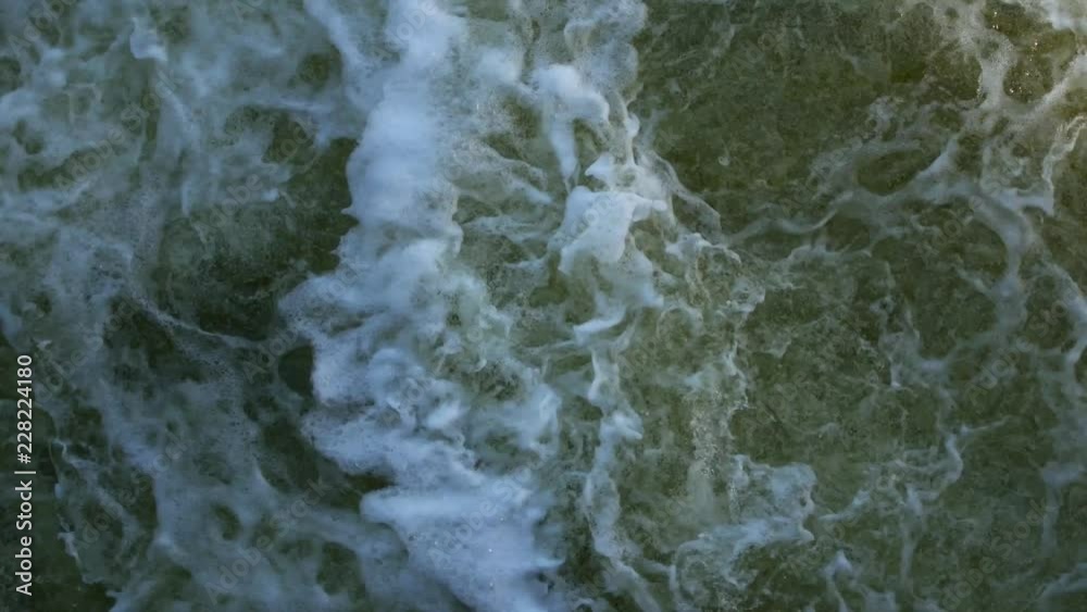 Streams of water on the river dam splashing out from the gateway and form waves. Close-up Streams of water on the river dam splashing out from the gateway and form waves. Close-up
