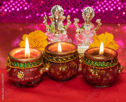 Diwali Background Showing Lit Lamps Against Idols of Deities Lakshmi and Ganesh photo