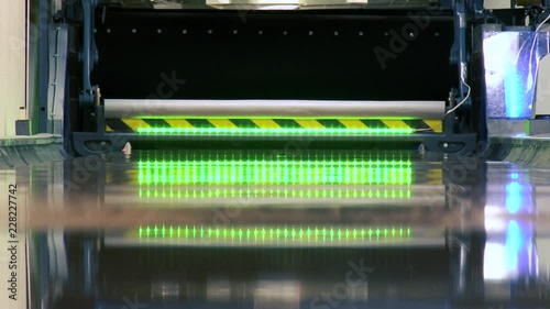 A floor shot of a blue bowling ball hits a strike removing all the pins with a straight shot before the sweep bar removes the remaining pins for the next shot, a creative reflected green light is seen photo