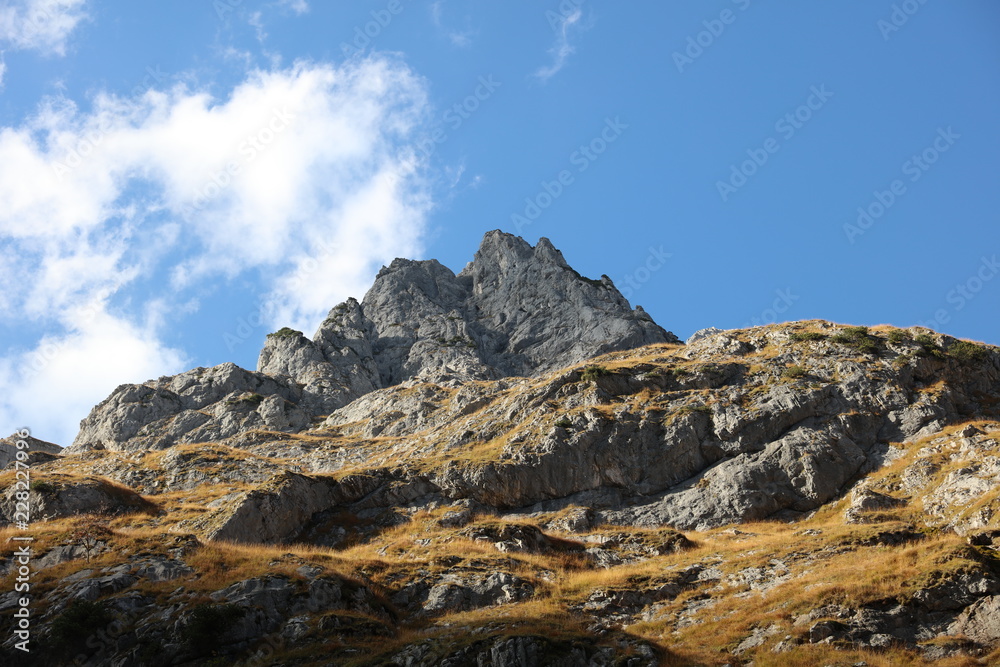 Sun cloud and shadow on mountain rocks with blue sky