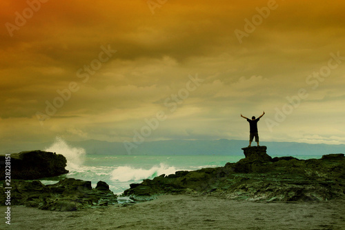 silhouette of man on the rock in cloudy sky
