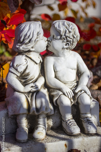 Valentine love, kissing statue and red leaves