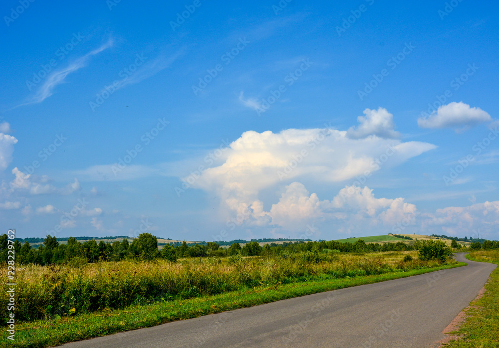 Landscape with beautiful large white clouds in the blue sky on a sunny day