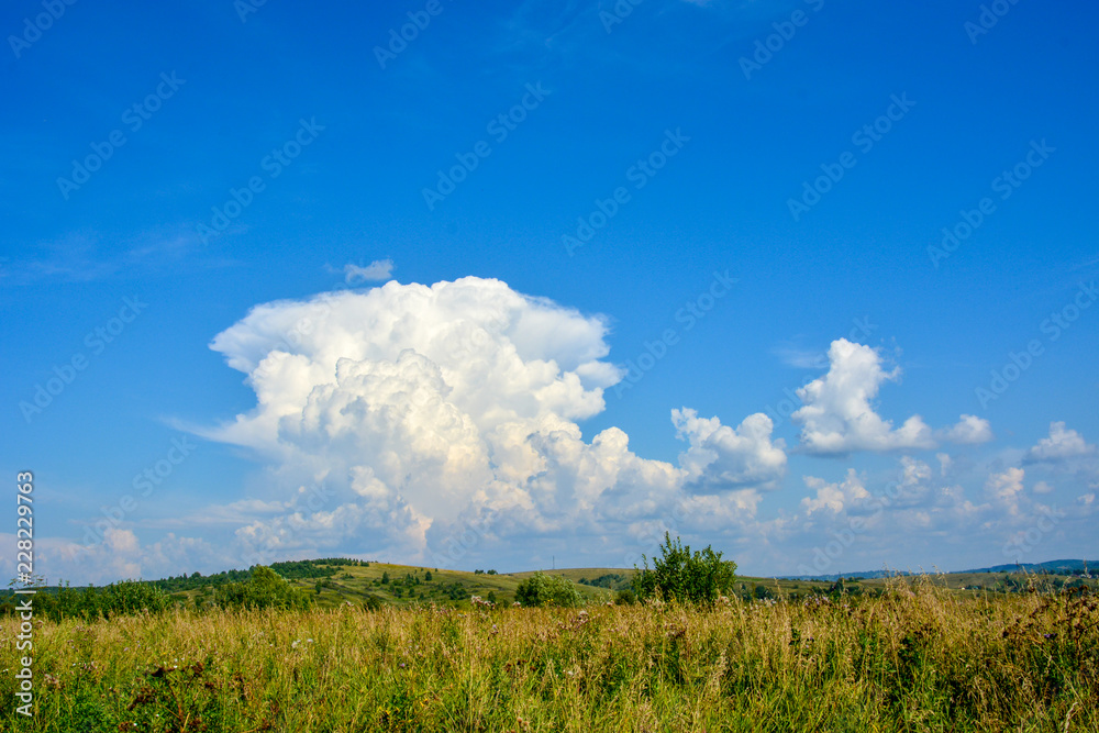 Landscape with beautiful large white clouds in the blue sky on a sunny day Landscape with beautiful large white clouds in the blue sky on a sunny day
