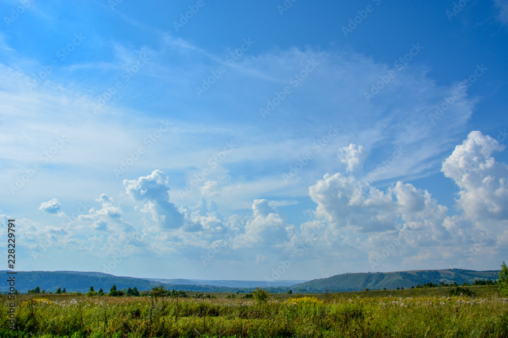 Landscape with beautiful large blue and white clouds on a blue sky on a sunny day Landscape with beautiful large blue and white clouds on a blue sky on a sunny day