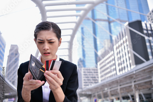 Concept of unemployed. Asian businesswoman is opening empty wallet. Young business woman is stressed because of no money. photo