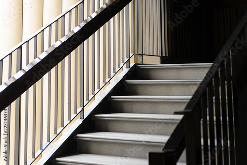 Empty Modern Concrete Staircase and black steel handrail with natural light  staircase in modern building - Dark Tone