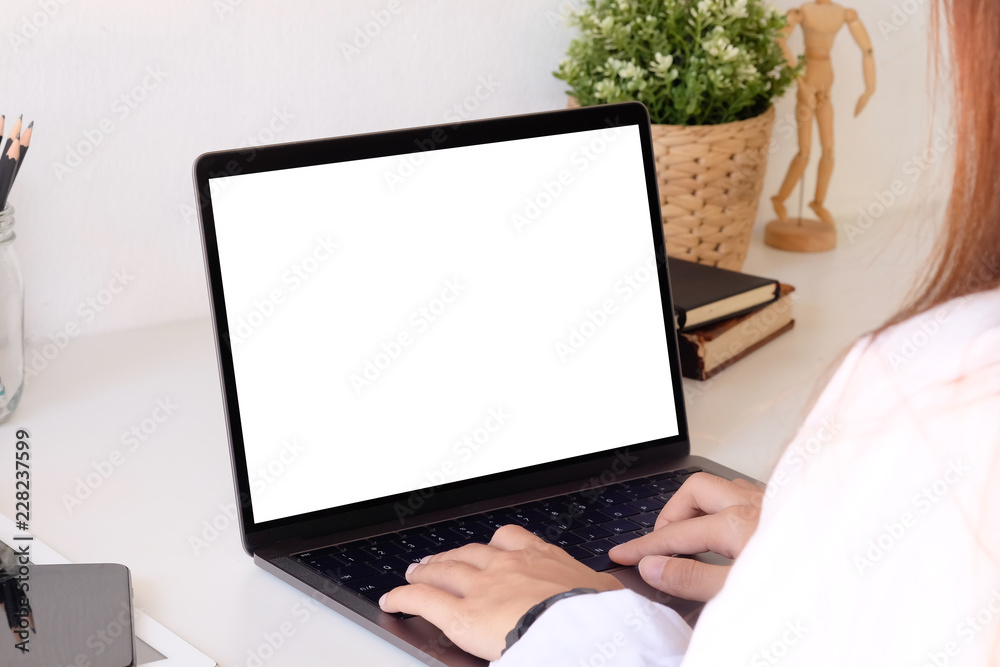 Fototapeta premium Female using mockup laptop computer on office desk.