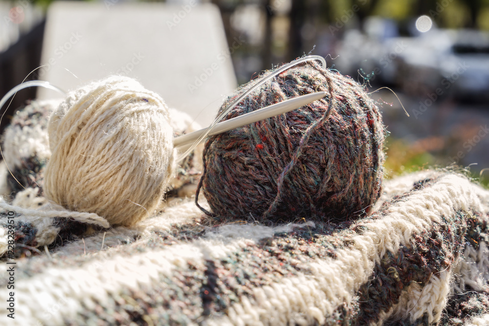 Hairs of wool, knitting needles and woolen clothes are prepared for work. Close-up Hairs of wool, knitting needles and woolen clothes are prepared for work. Close-up