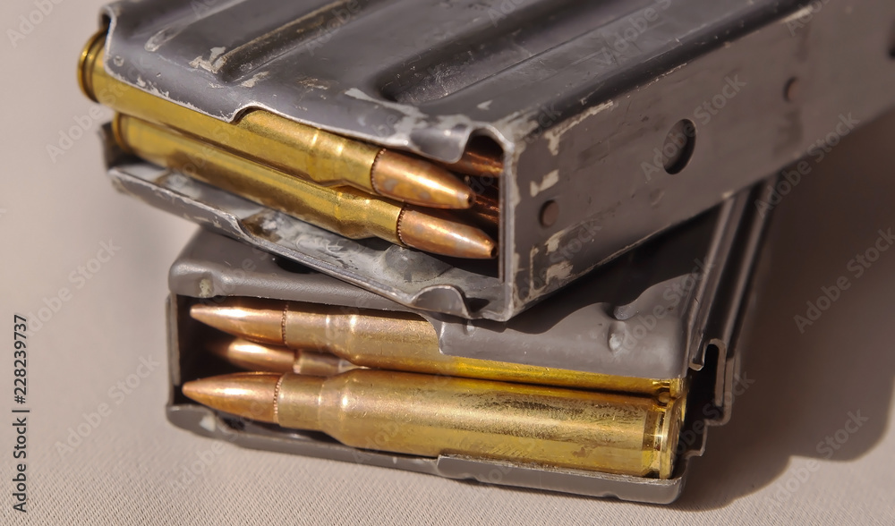 Two metal rifle magazines, one stacked upon the other, loaded with .223 ...
