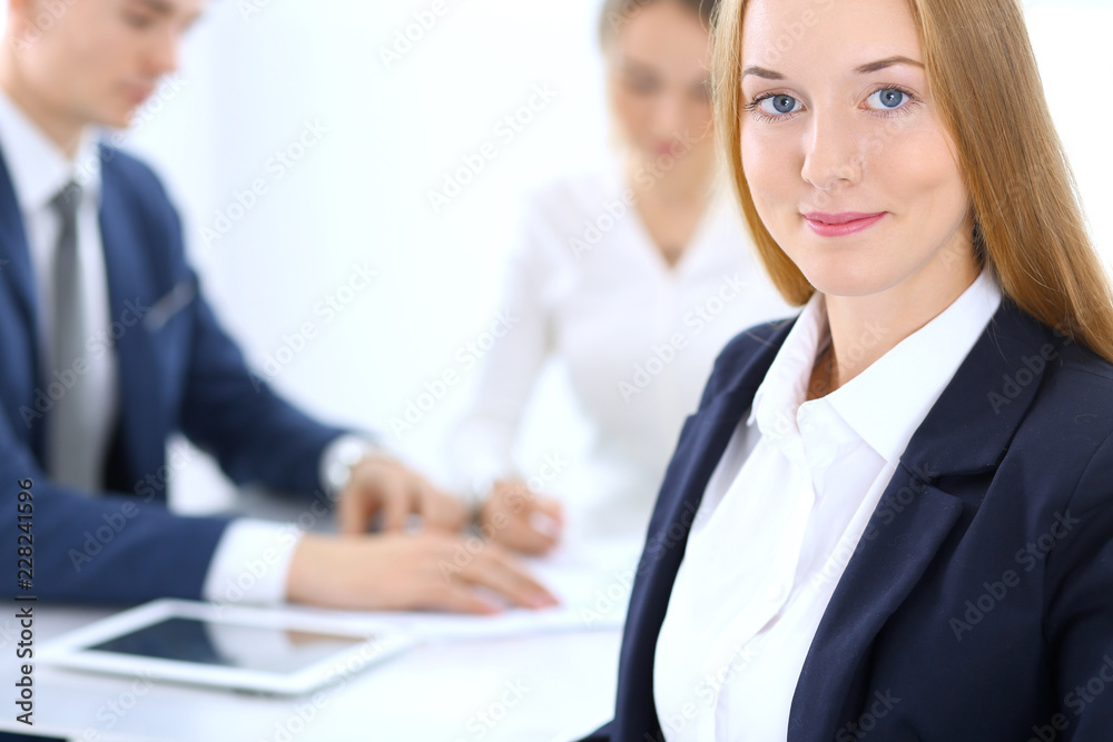 Group of business people or lawyers discussing terms of transaction in office. Focus at young business woman. Meeting and teamwork concept Group of business people or lawyers discussing terms of transaction in office. Focus at young business woman. Meeting and teamwork concept