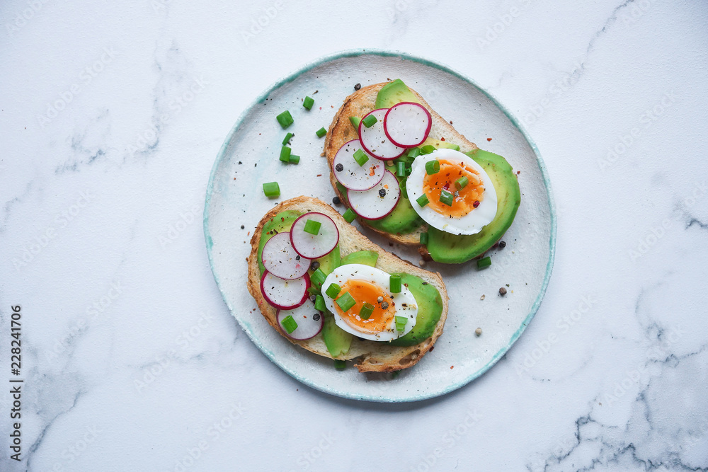 Healthy breakfast, Toasts with avocado, egg, radish, sweet onions and tomatoes, Diet food, On a light marble background, Selective focus, Copy space, Top view Healthy breakfast, Toasts with avocado, egg, radish, sweet onions and tomatoes, Diet food, On a light marble background, Selective focus, Copy space, Top view
