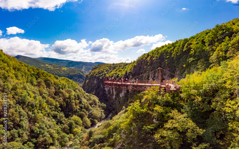 Beautiful panoramic view from the drone to Tourists On Observation Platform on Suspension Bridge Up To 140 Meters Above Precipice Okatse Canyon, Zeda-gordi, Dadiani park Kutaisi, Georgia.