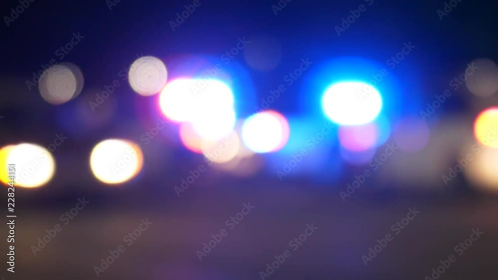 Police vehicle emergency lights flashing at night at an accident scene