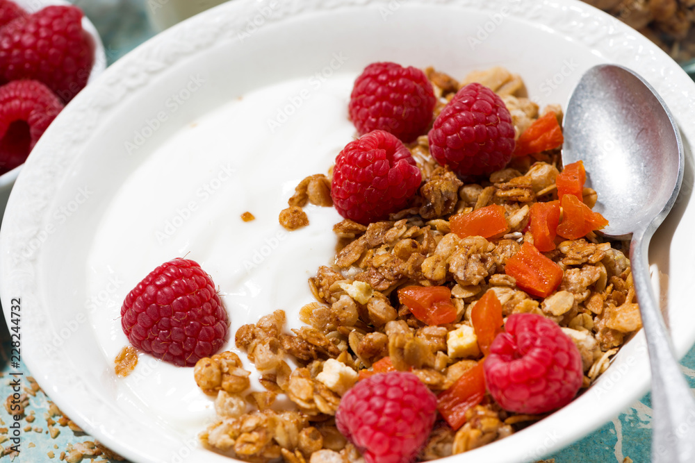 granola with dried apricots, raspberries and yogurt for breakfast, closeup granola with dried apricots, raspberries and yogurt for breakfast, closeup