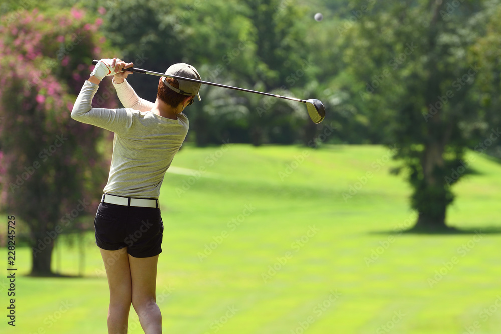 Woman playing golf on a beautiful natural golf course Woman playing golf on a beautiful natural golf course