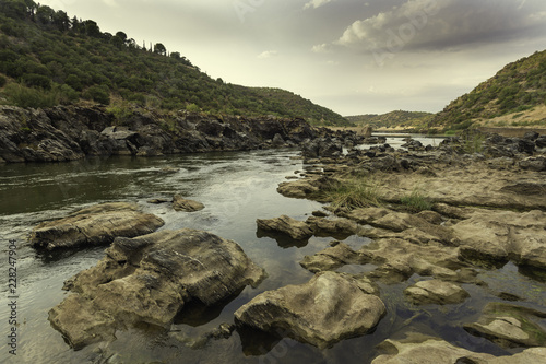 Course of the Guadiana River with its calm waters between the mountains and the rocks of the riverbed