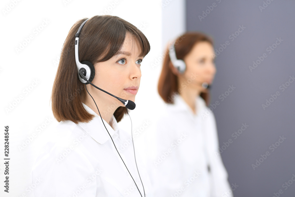 Call center. Group of operators at work. Focus on young brunette woman. Business concept Call center. Group of operators at work. Focus on young brunette woman. Business concept